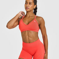EnhanceLift™ Seamless Strappy Sports Bra with White Logo | Charged Coral