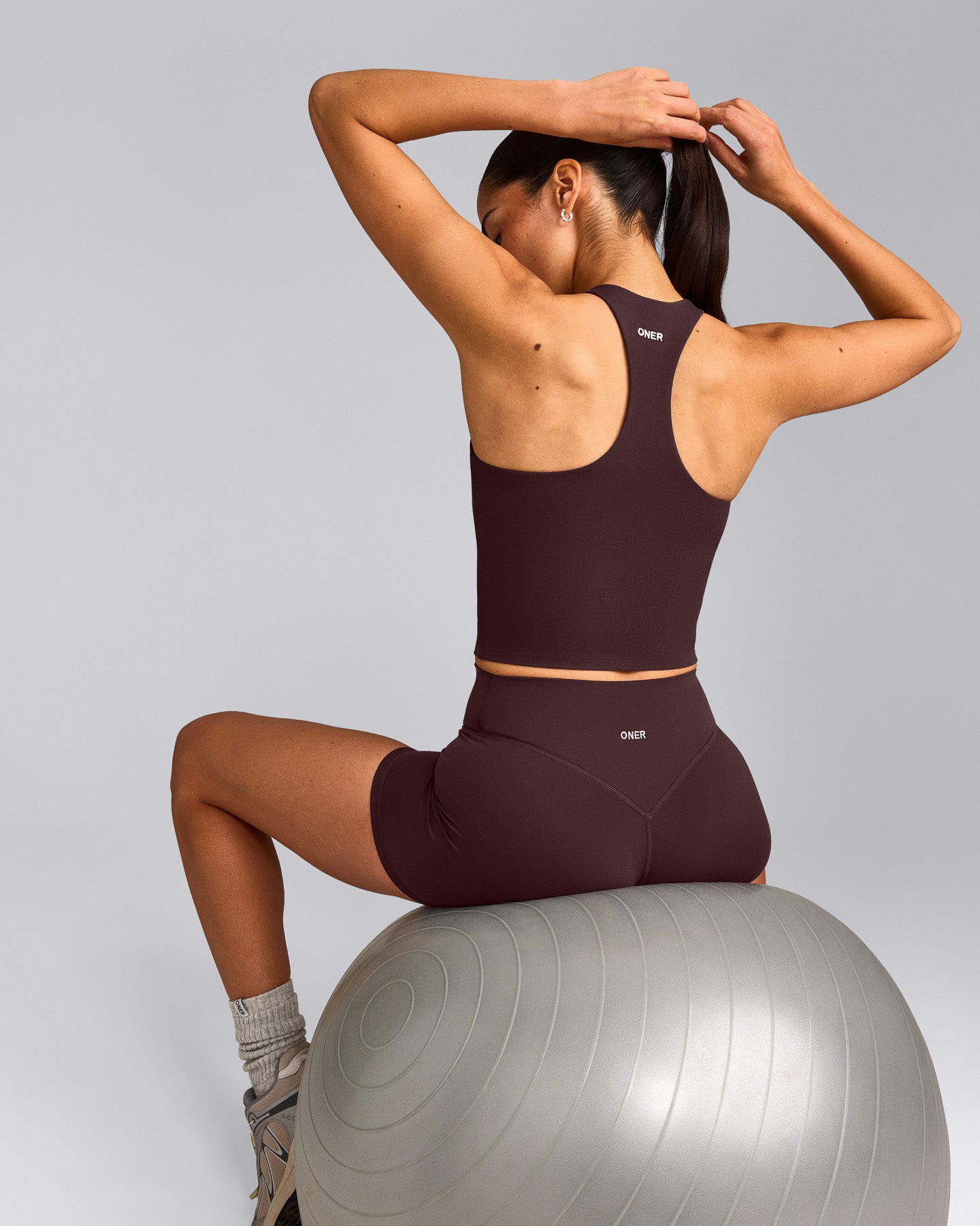 SoftMotion™ Racer Back Mid Tank Top with Built in Bra Shelf with Gray Logo | Plum Brown