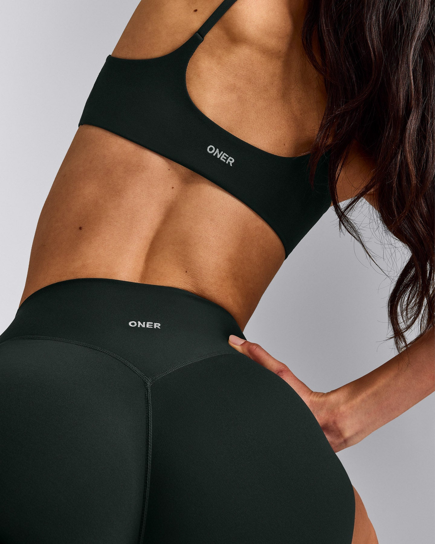 SoftMotion™ Strappy Sports Bra with Gray Logo | Emerald Noir