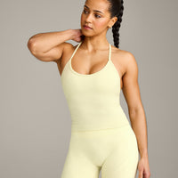 EnhanceLift™ Seamless Strappy Racer Tank Top with Built in Bra Shelf with Gray Logo | Pastel Yellow