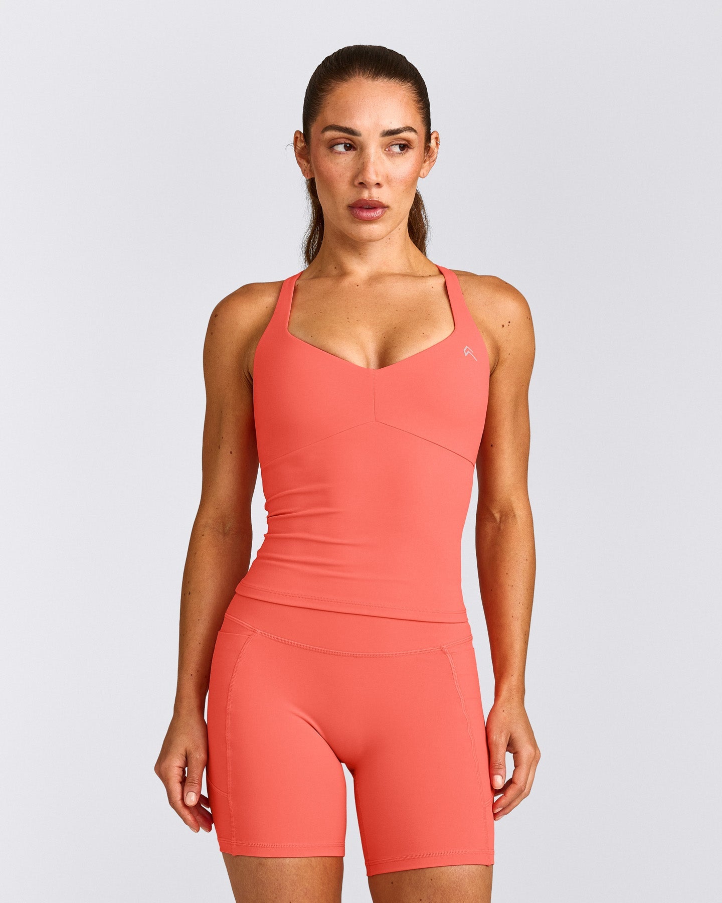 UnifiedMove™ T Back Mid Tank Top with Built in Bra Shelf with Reflective Logo | Light Charged Coral